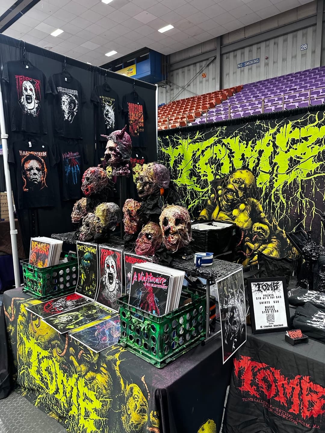 The Tomb Gallery booth at a horror convention, with sculpted heads and print racks